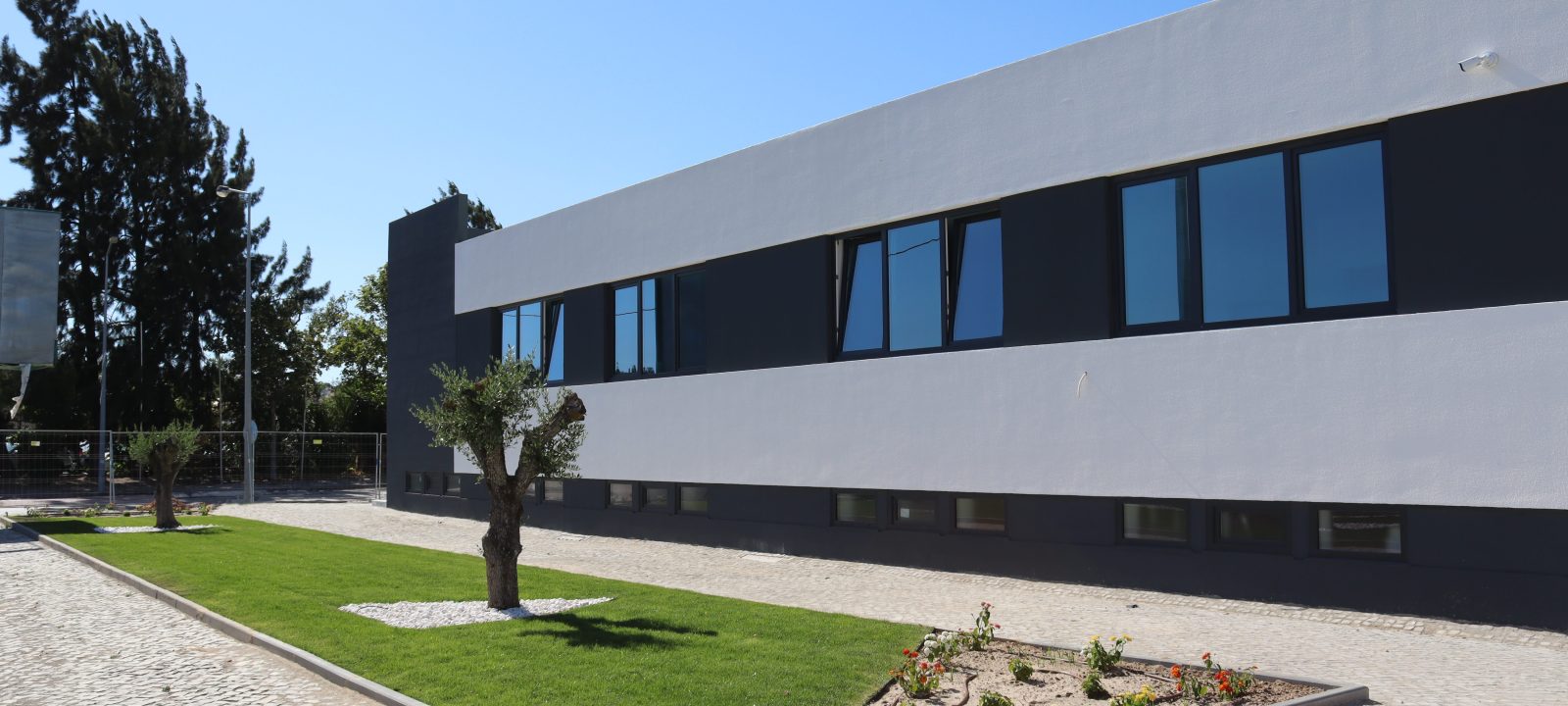 Imagem de uma casa/empresa branca, com um pequeno jardim