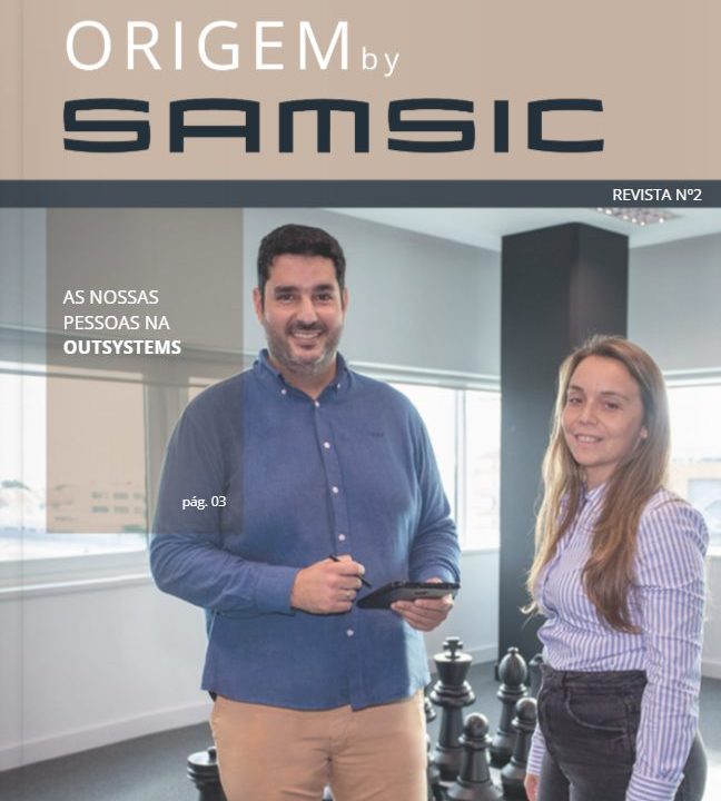 Revista Origem - duas  pessoas com um xadrez atrás dentro de um escritório